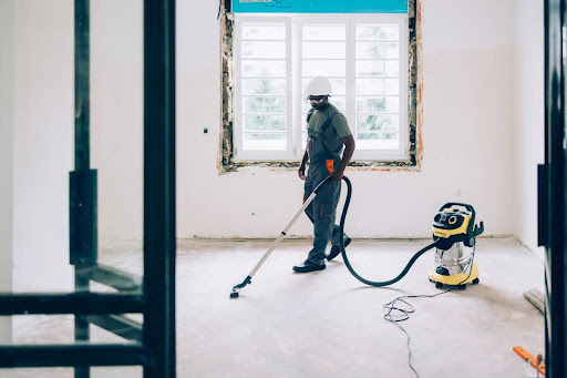 Nhân viên dùng máy hút công nghiệp giúp làm sạch sàn nhà sạch sẽ