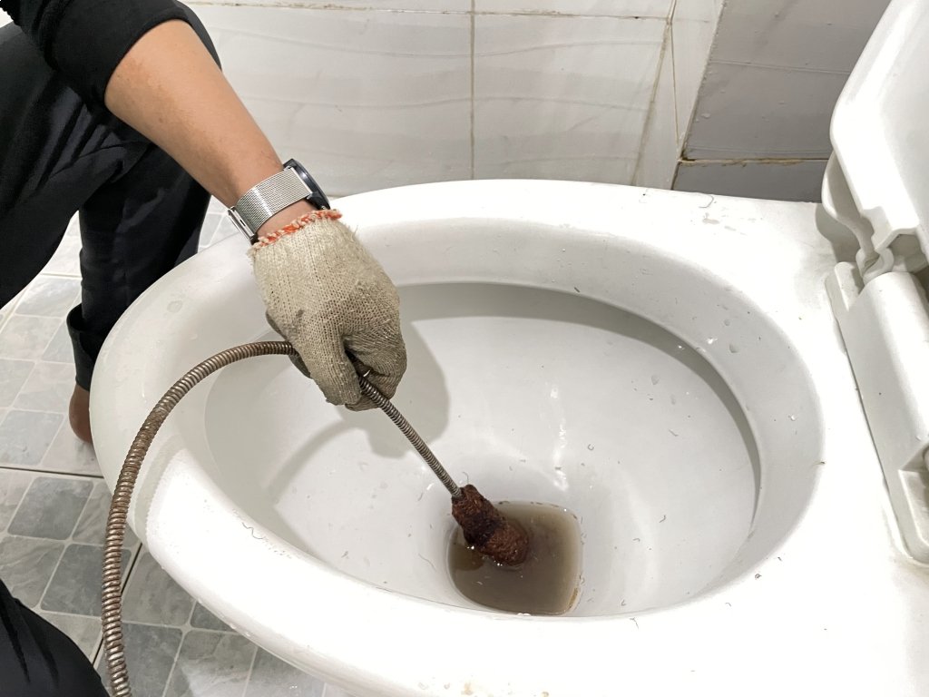 Sử dụng dụng cụ lò xo thông tắc (dây thông bồn cầu) để xử lý bồn cầu INAX bị tắc nước